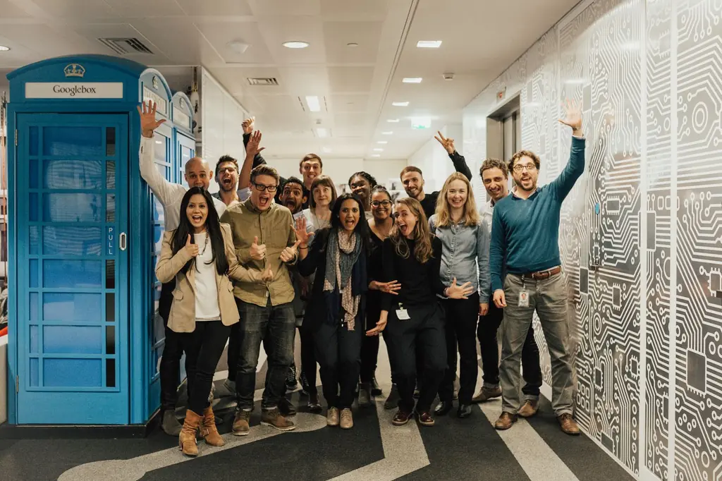 A Talentrade cohort cheers together in an office hallway at the end of a program