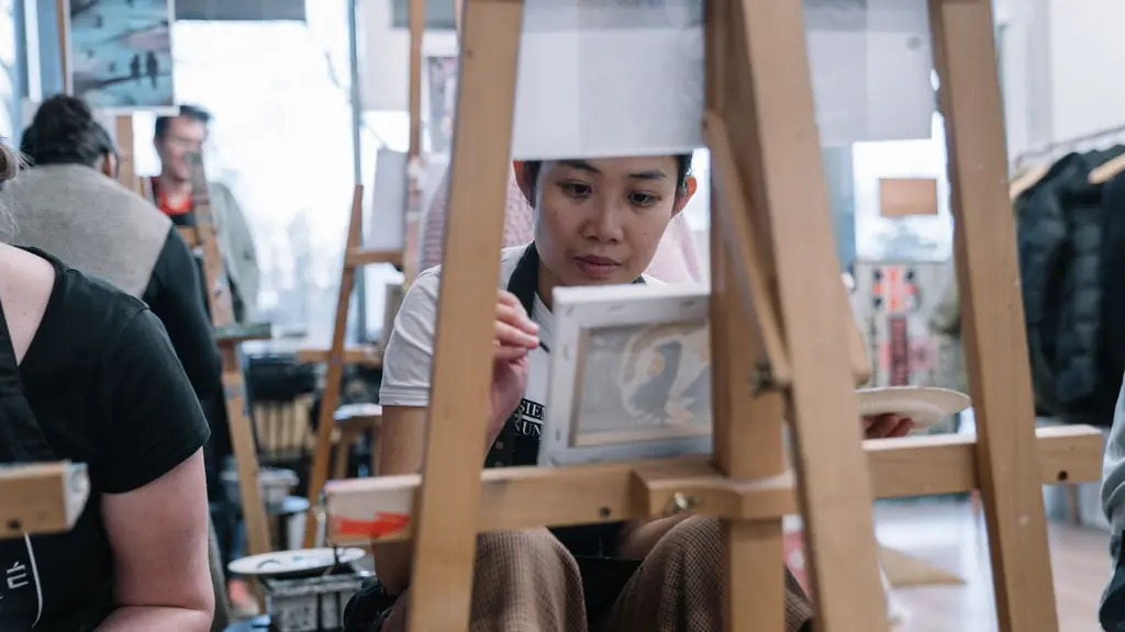 A learner works on a sketch at an easel during a hands-on session